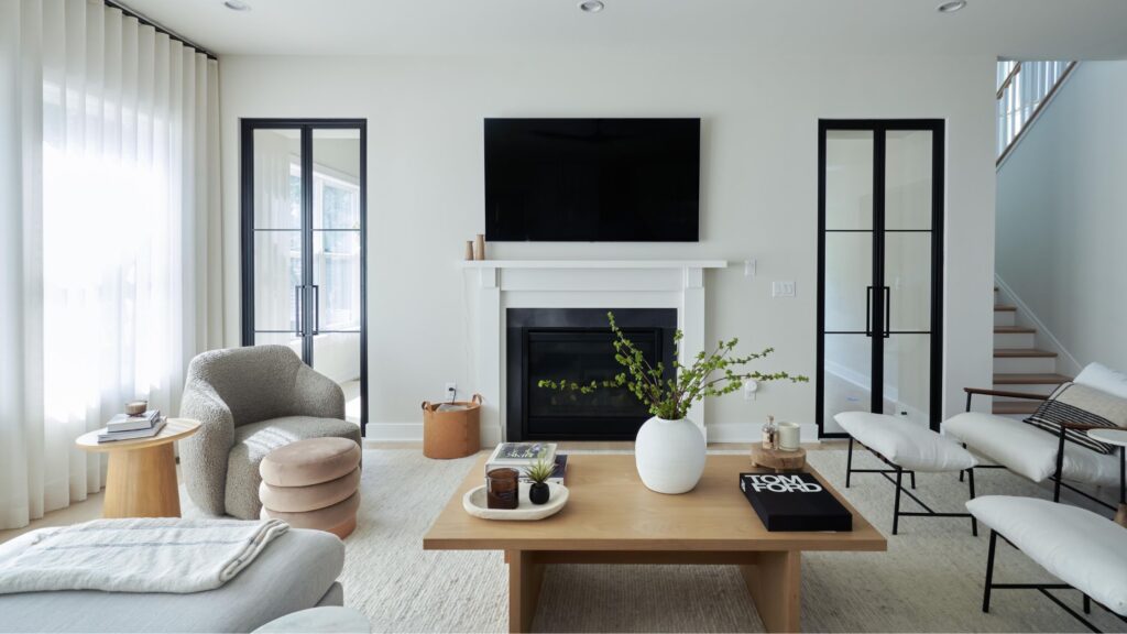 home interior showing a gorgeously decorated family room with a fireplace flanked by windows and tasteful decorations throughout